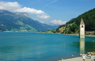 Scenic view of sea by mountains against sky