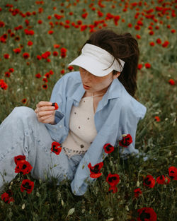 Rear view of woman with flowers on field