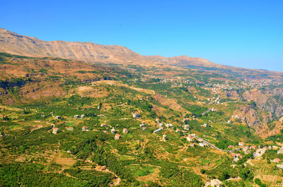 Scenic view of rocky mountains against clear blue sky on sunny day