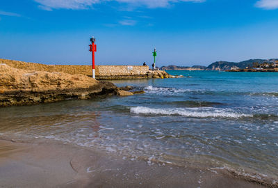 Lighthouse by sea against sky