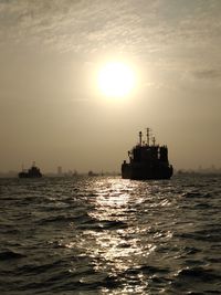 Boat sailing on sea against sky during sunset