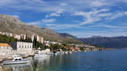 Scenic view of townscape by mountains against sky