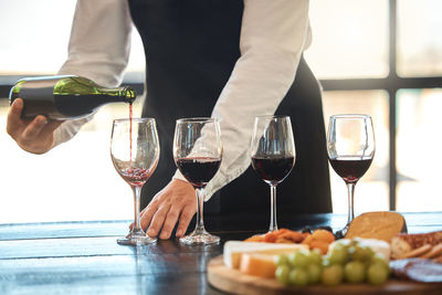 Midsection of woman holding wineglass