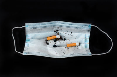 Close-up of cigarette smoking against black background