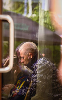 Side view of man looking through window