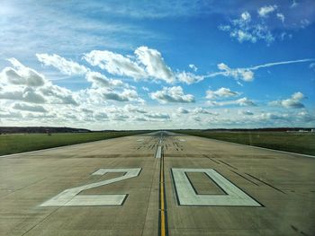 Numbers on airport runway against sky