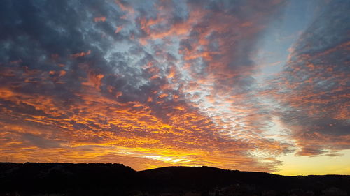 Low angle view of silhouette mountain against dramatic sky