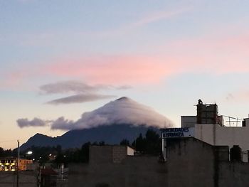 Smoke emitting from factory against sky