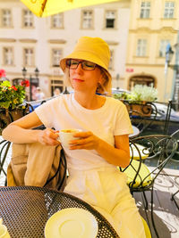 Portrait of smiling young woman sitting at table