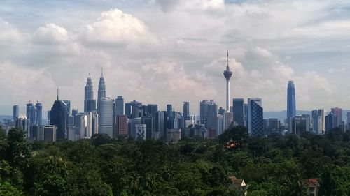 View of buildings in city against cloudy sky