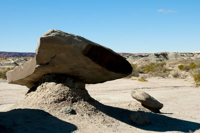 Rocks on beach against clear sky