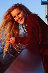 Portrait of smiling young woman standing in balcony