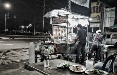 People on illuminated street in city