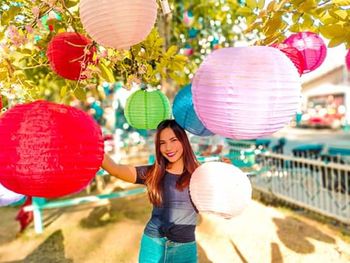 Portrait of a smiling young woman holding balloons