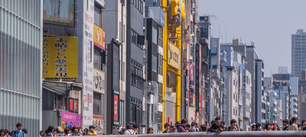 People on city street against buildings