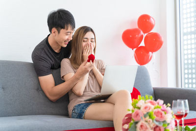 Young woman sitting on sofa at home