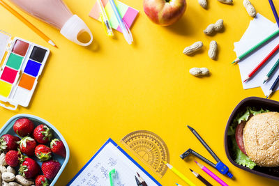 High angle view of lunch with school supplies on table 