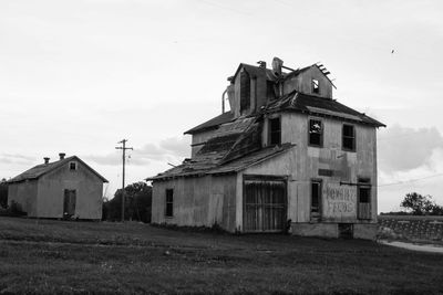 Low angle view of old house on field against sky