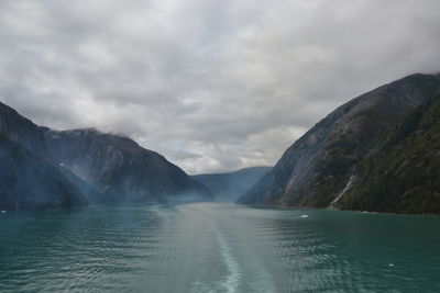 Scenic view of lake by mountains against sky