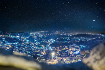 Aerial view of illuminated cityscape against sky at night