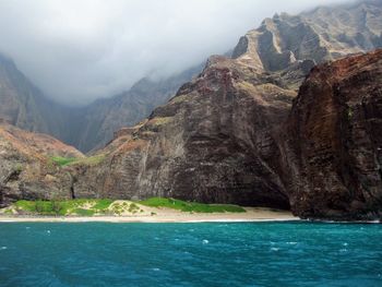 Scenic view of sea and mountains against sky
