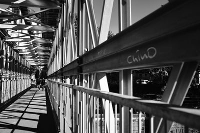 Rear view of man walking on footbridge