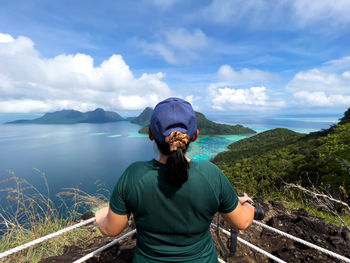 Rear view of man standing against lake