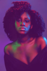 Portrait of young woman against colored background