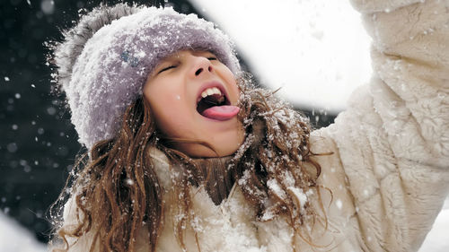 Winter family fun catch snowflakes with tongue happy cutie pretty little girl is catching snowflakes
