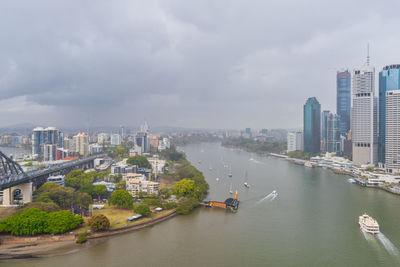 River amidst buildings in city against sky