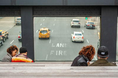 Rear view of people walking on road in city