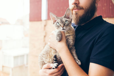 Portrait of man holding cat