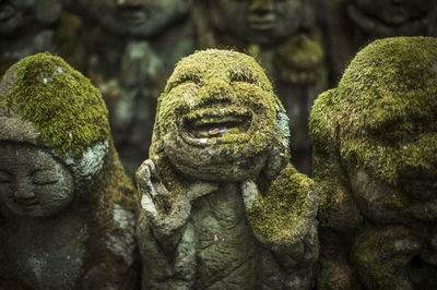 Close-up of old moss covered statues