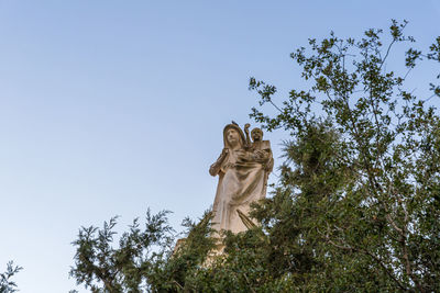 Low angle view of angel statue against clear sky