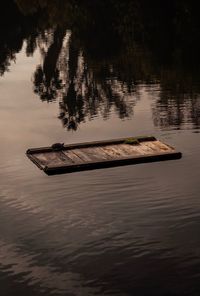 Boat floating on lake during sunset