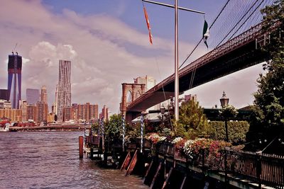 Bridge over river against cloudy sky