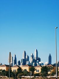 Dubai marina skyline rising above villas along garn al sabkha street in dubai under clear skies. 