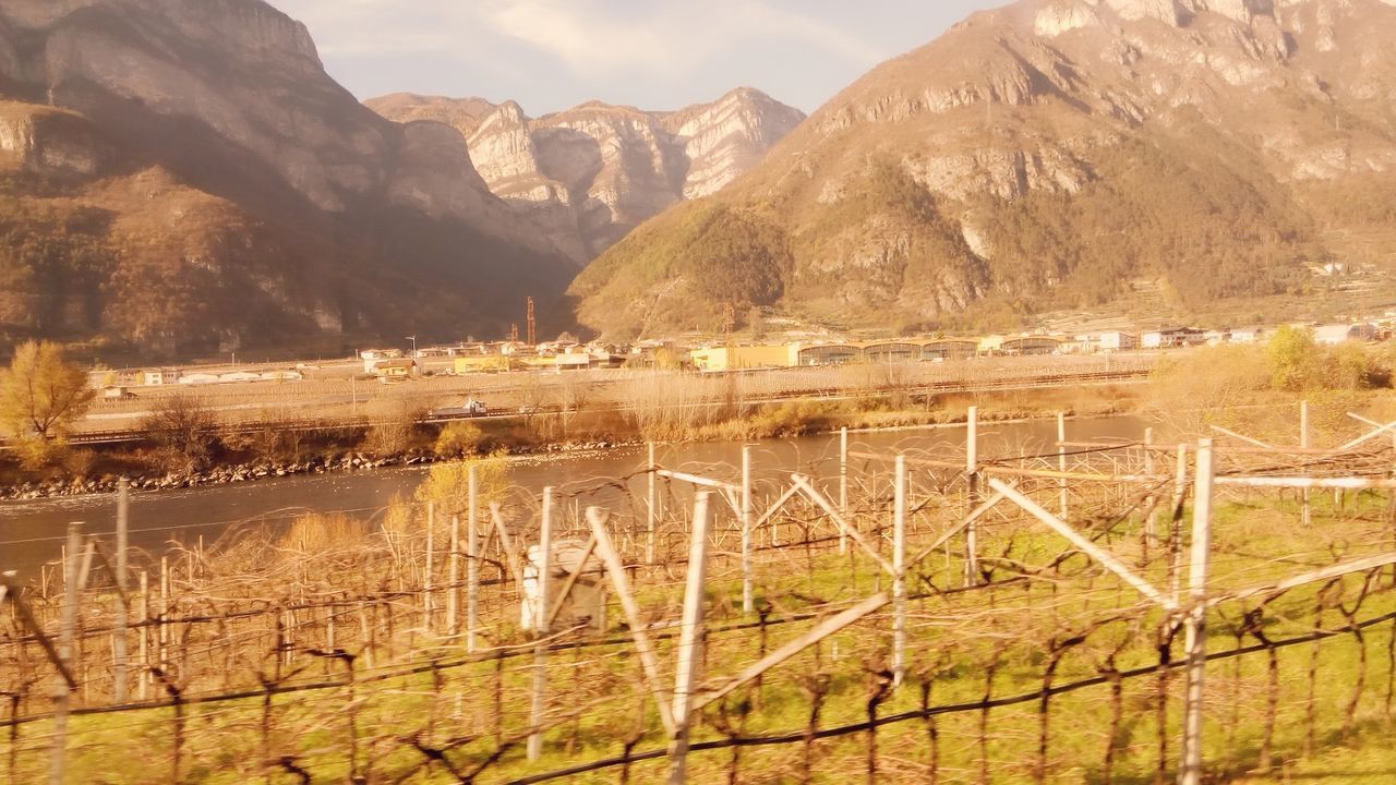 mountain, mountain range, built structure, tranquility, tranquil scene, architecture, sky, scenics, landscape, beauty in nature, railing, nature, fence, building exterior, day, non-urban scene, tree, water, outdoors, no people