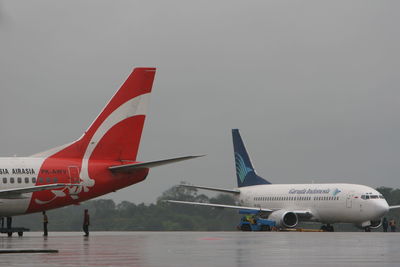 Airplane on airport runway against sky