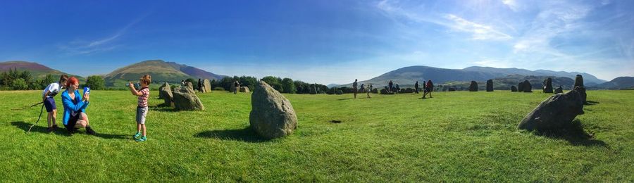 Boy photographing mother and brother at castlerigg stone circle