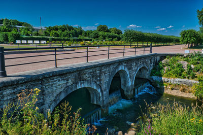 Arch bridge over river against sky