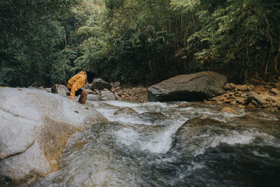 Male traveller explore the beautiful of rainforest stream in the morning.hiking and camping.