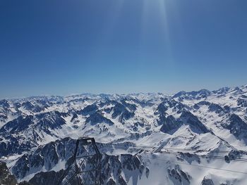 Scenic view of snowcapped mountains against blue sky