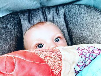 Close-up portrait of baby boy on bed