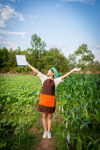 Full length of woman standing on field against sky