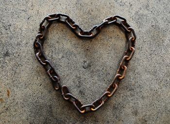 Directly above shot of heart shape chain on footpath