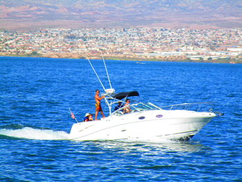 People sailing in sea against sky