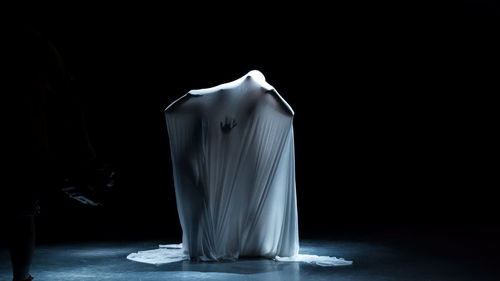 Rear view of woman standing against black background