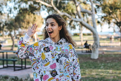 Teenager girl waving hand and greeting friends