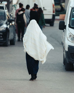 Rear view of people walking on street